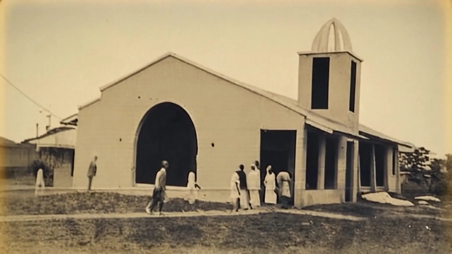 Fotografía histórica de una estructura temprana del templo principal con fachada y campanario.