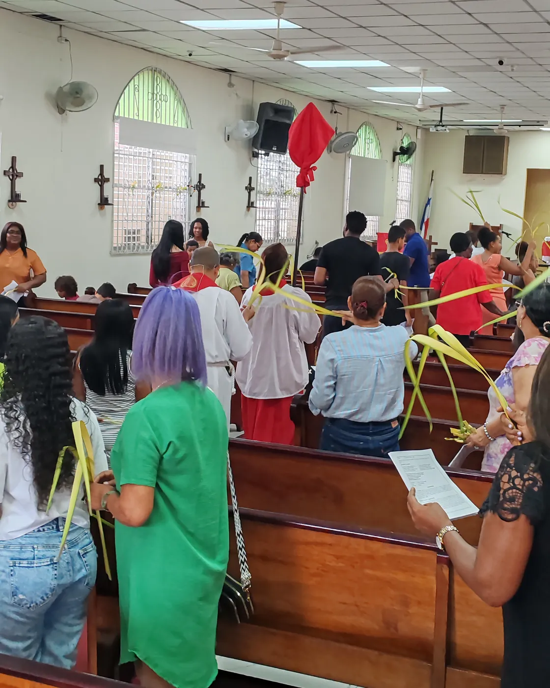 Comunidad parroquial participando en una celebración litúrgica con palmas